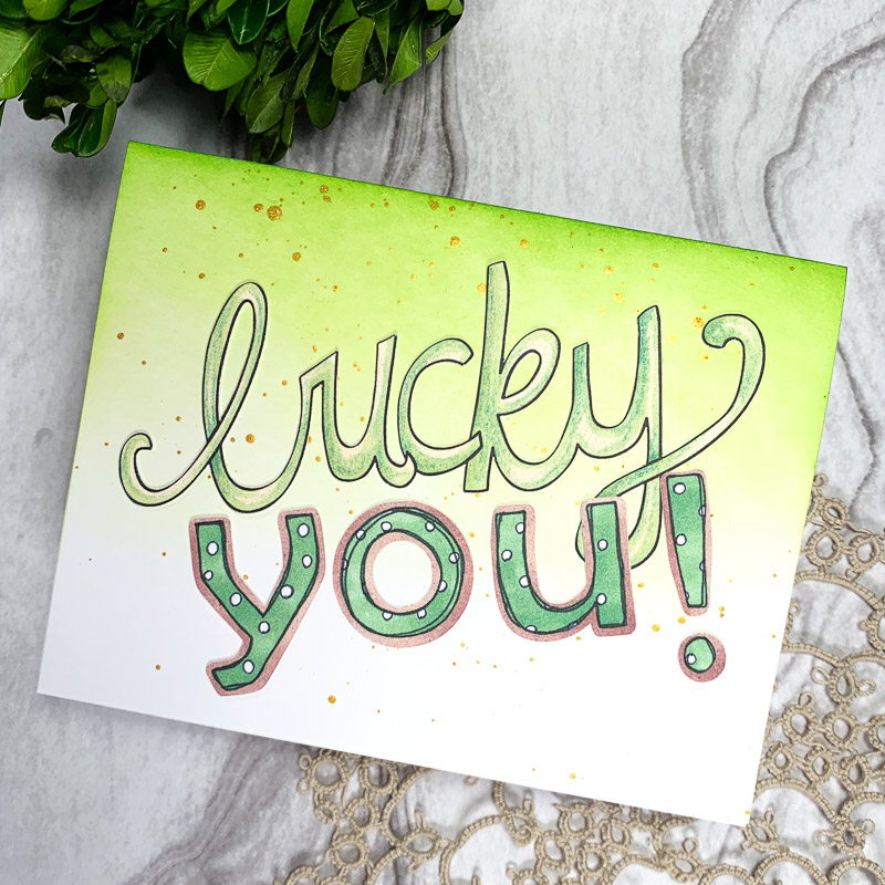 handmade St Patrick's Day card with lucky you sentiment on a green and gold spattered background