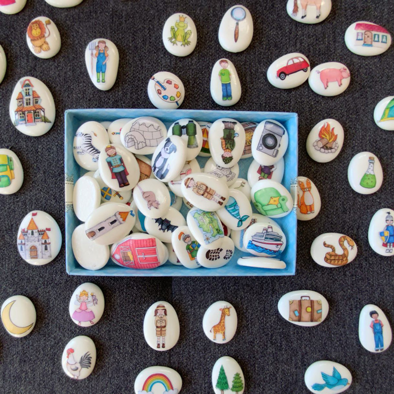 collection of hand made story stones featuring different characters on a dark background