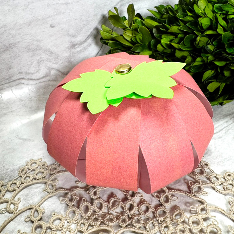 hand made paper pumpkin decoration on a marble table top